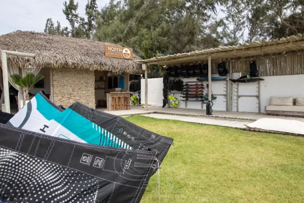  North Kite Center chez Preabeach avec voile de kite au premier plan et équipements exposés