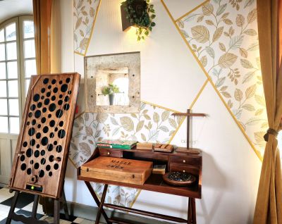 Coin jeux et salon de l hotel Le Prince Noir avec jeux en bois et malle de jeux 1