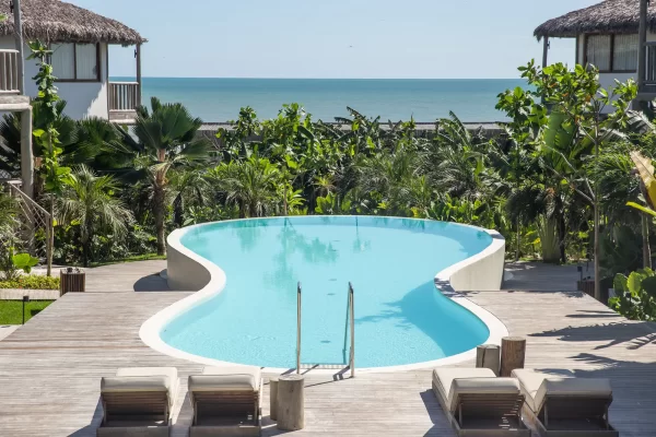 Yemanja's curved pool surrounded by palm trees and dense tropical vegetation