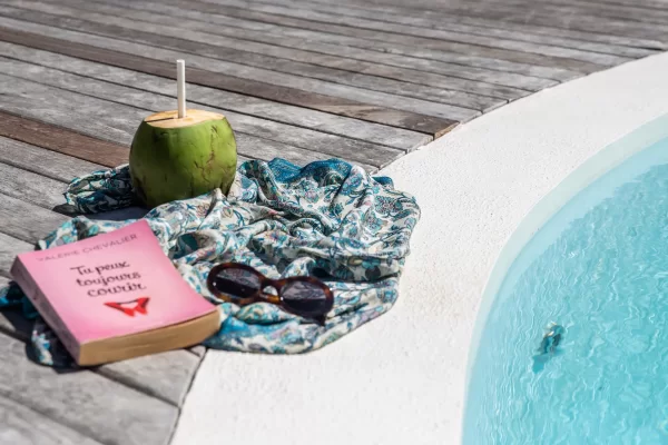 Relaxing poolside moment at Yemanja with coconut, book and sunglasses