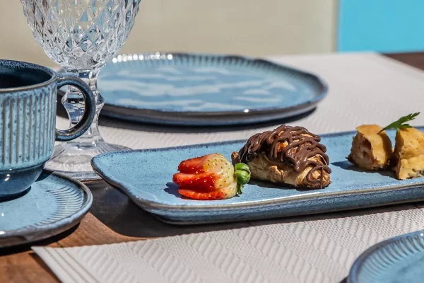 Chocolate-drizzled filled pastry with fresh strawberry, part of Yemanja's breakfast spread